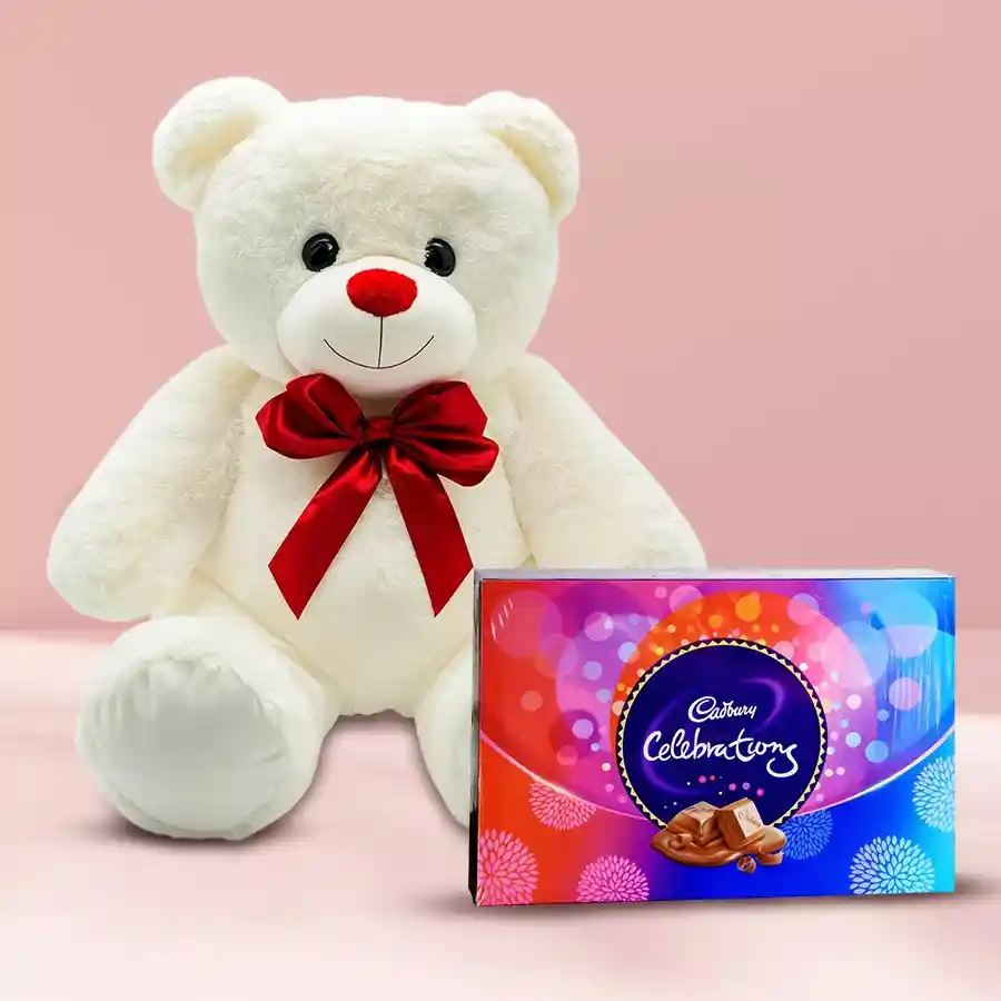 Big White Teddy bear with a red bow next to a box of Cadbury Celebrations chocolates