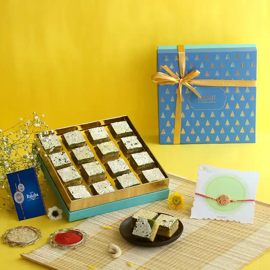 Charming Rakhi & Pista Barfi Delight gift box with a Red Flower Rakhi and 16 pieces of Pista Badam Barfi.