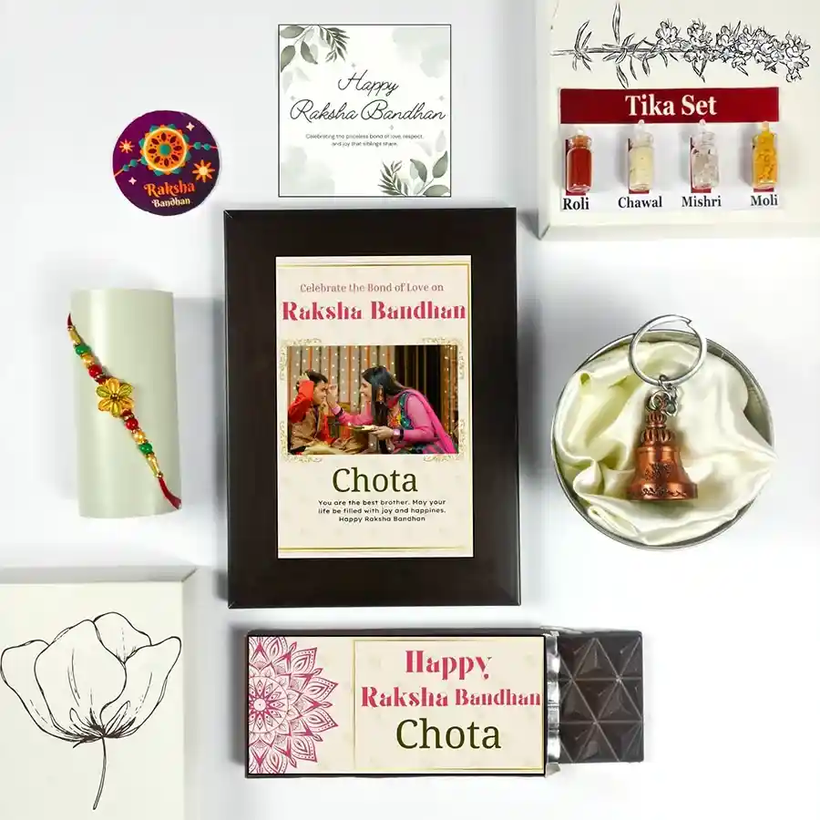 Heartfelt Rakhi Delight Box with chocolate bar, photo frame, Rakhi, greeting card, guardian bell, and tika set for celebrating Raksha Bandhan.