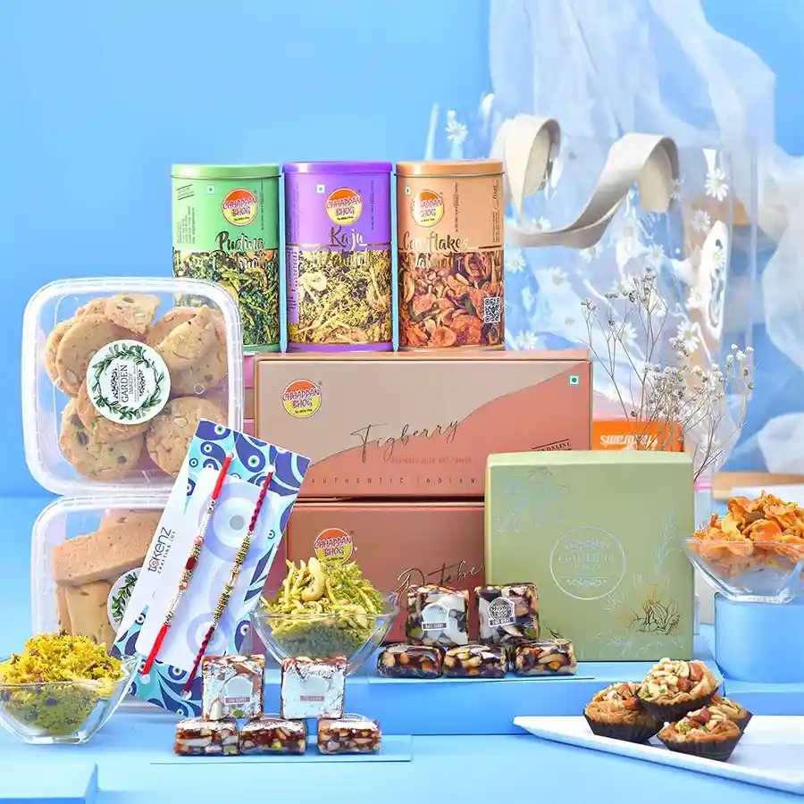 Twin Rakhi Gourmet Treat Hamper with Rakhis, cookies, and snacks in a floral gift bag.