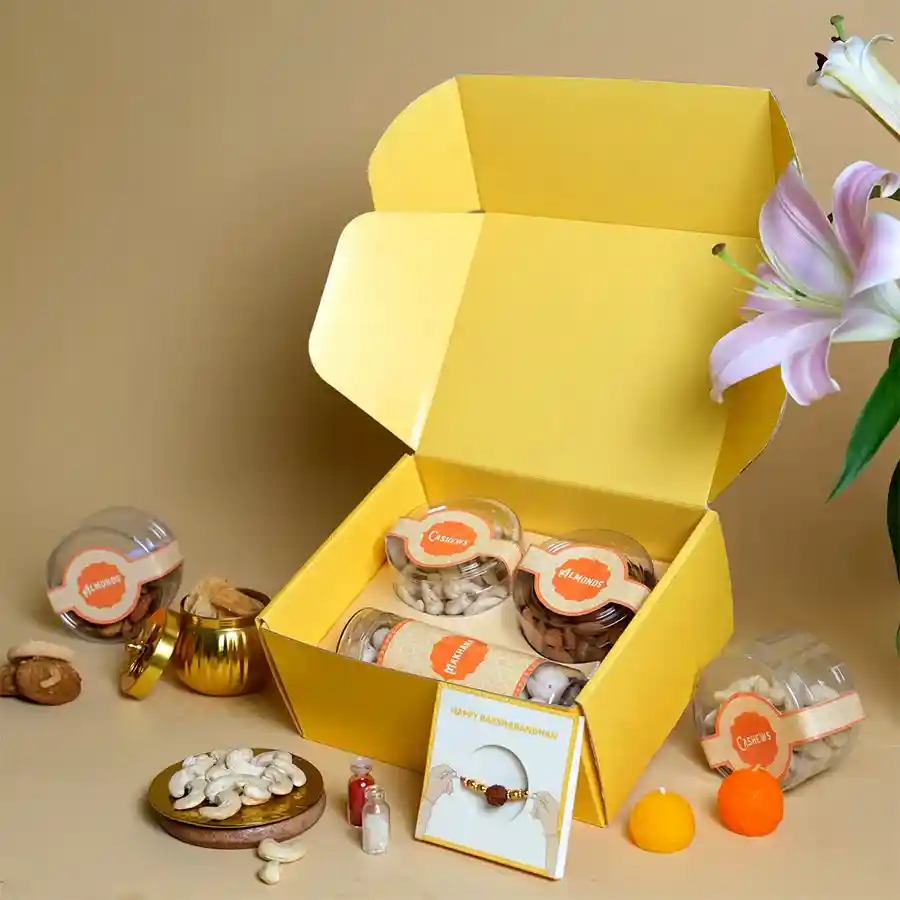 Healthful Rakhi Snack Surprise Pack with Rudraksha Rakhi and assorted nuts in a bright yellow box.
