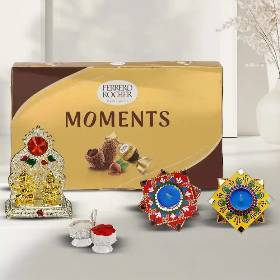 A beautifully arranged gift box featuring an antique Ganesh Laxmi Mandap, 16 Ferrero Rocher chocolates, and 2 handmade Dot Mandala Art Diyas, along with complimentary Roli, Tika, and Chawal, set against a festive background.