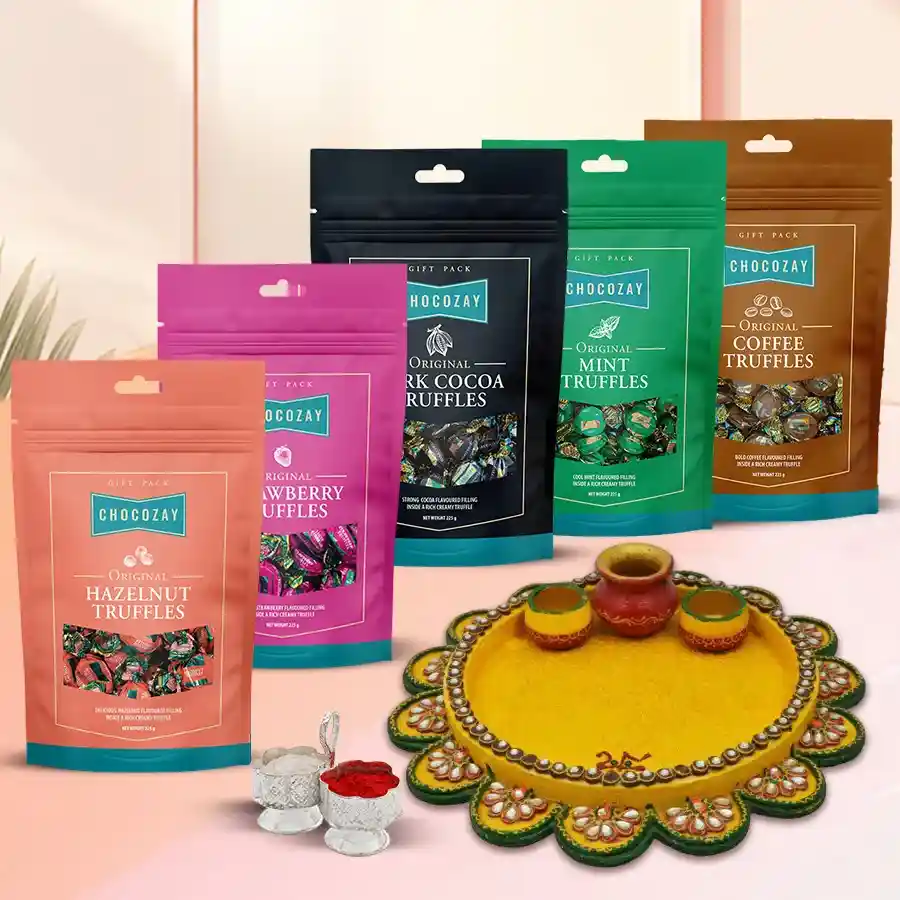 Assorted truffle chocolates in a decorative box next to a beautifully designed Pooja Thali and Roli Tika for Bhai Dooj celebration