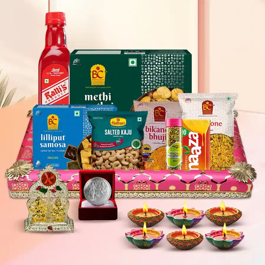Diwali gift hamper with assorted snacks, Diyas, a Ganesh-Laxmi Mandap, a silver-plated coin, and a decorated tray.