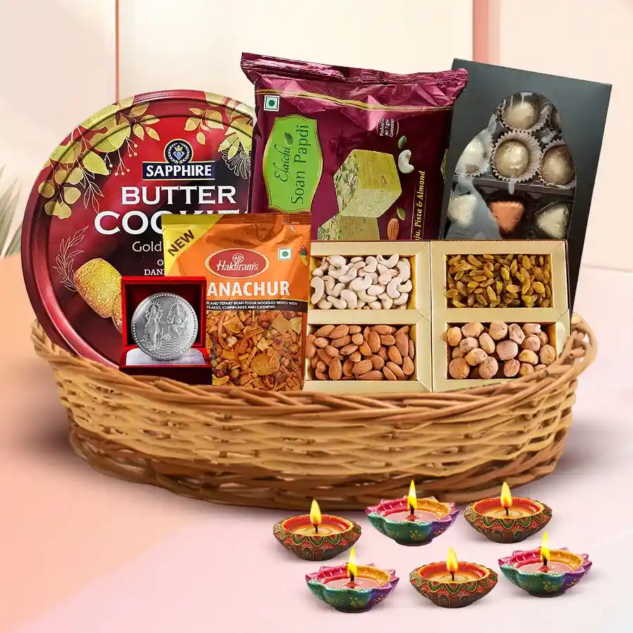 Exclusive Diwali Hamper featuring a stylish cane basket filled with imported cookies, premium dry fruits, Haldiram’s snacks, handmade chocolates, decorated diyas, and a silver-plated Laxmi Ganesh coin