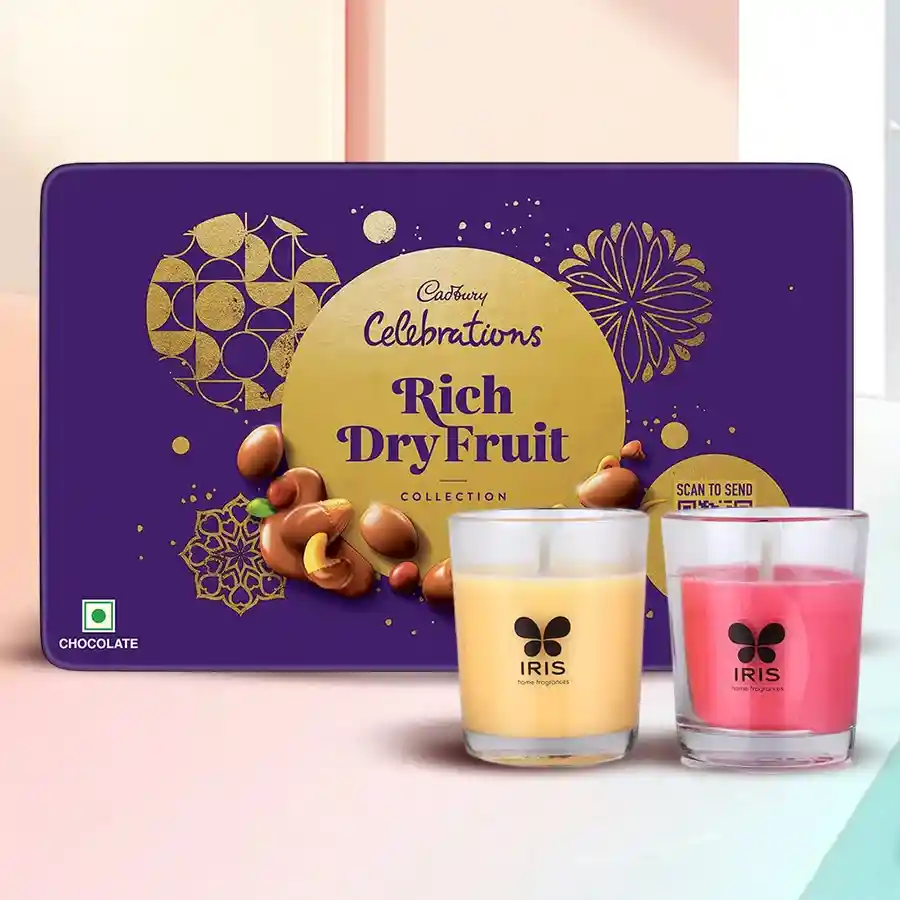 Festive gift set featuring a Cadbury Rich Dry Fruit tin, two Iris Aroma Shot candles, and decorative packaging.