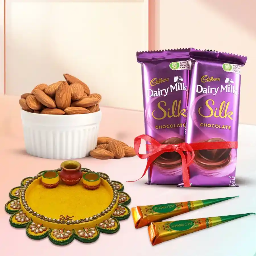 A beautifully arranged Karwa Chauth Shagun Hamper featuring a designer pooja thali, two Cadbury Dairy Milk Silk bars, 100g of almonds, and two herbal mehndi cones.