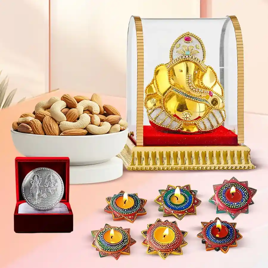 A beautifully arranged Diwali gift set featuring a Vighnesh Ganesh idol, assorted dry fruits, six handmade Dot Mandala wax diyas, and a silver-plated Ganesh Laxmi coin.