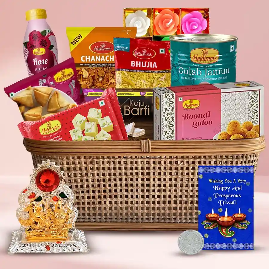 Diwali gift hamper featuring sweets like Kaju Barfi, Soan Papdi, and Gulab Jamun, along with savory snacks Mini Samosas and Bhujia, decorative candles, an Ethnic Ganesh Lakshmi Mandap, and a silver-plated coin.