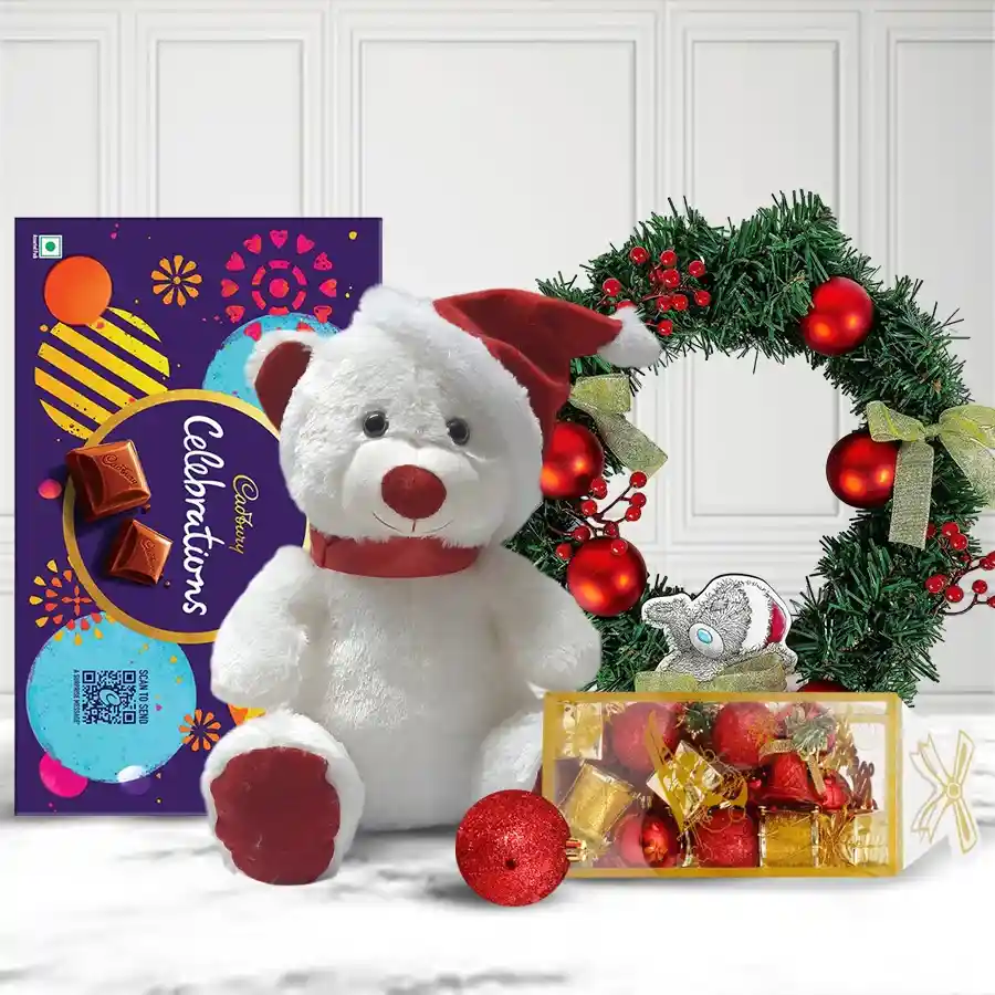 Cadbury Celebrations gift set with a 16-inch white teddy in a red cap, a 126g pack of chocolates, a decorated wreath, and Christmas décor.