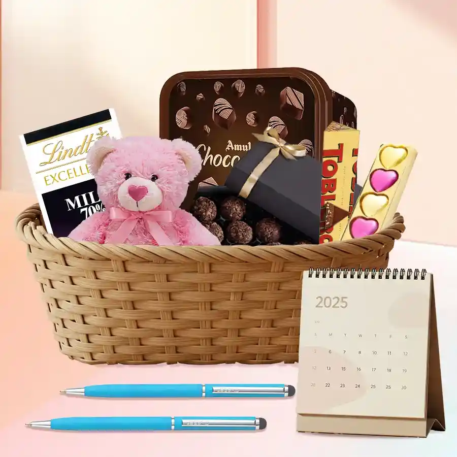 Delightful Choco Gift Basket featuring teddy bear, Toblerone and Lindt chocolate bars, heart-shaped chocolates, Amul Choco Minis, stylish pens, and a desk calendar, all arranged in a charming basket