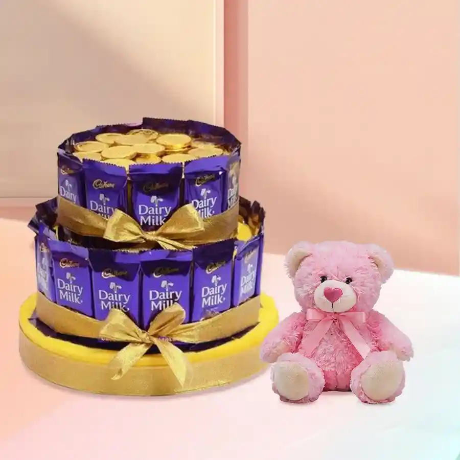 Two-tier chocolate arrangement featuring Cadbury Dairy Milk chocolates, gold coin chocolates, and a 6-inch teddy bear on a golden base, tied with a ribbon.