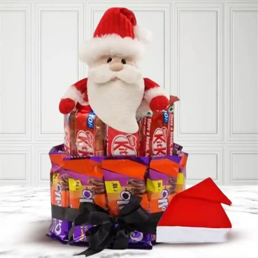 Two-tier chocolate arrangement featuring Nestle KitKats and Cadbury Crispellos, accompanied by a 6-inch teddy bear, a soft Santa Claus toy, and a festive Santa cap.