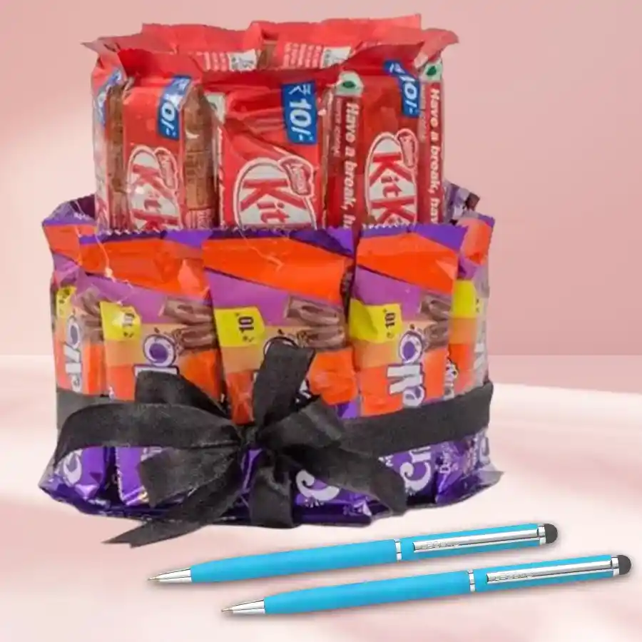 Double-deck chocolate arrangement featuring Nestle Kitkats and Cadbury Crispellos alongside two sleek ballpoint pens.