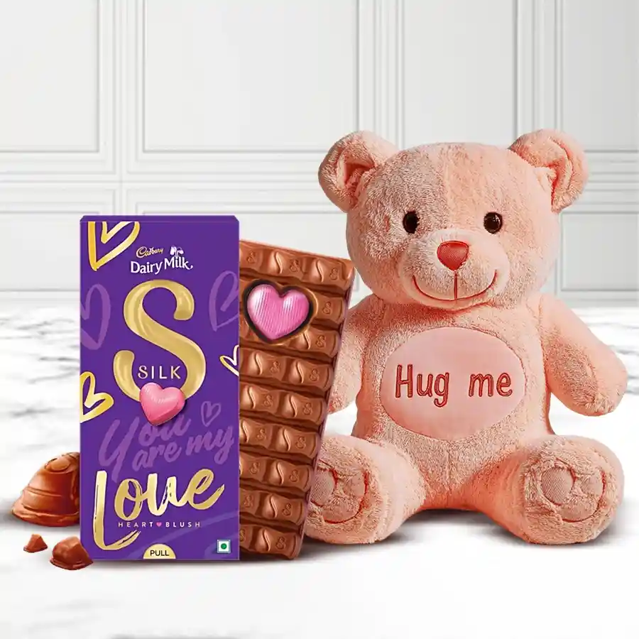 Hug Me Teddy holding Cadbury Silk Heart Pop-Up Chocolate on a festive background for Dazzling Hug Day.