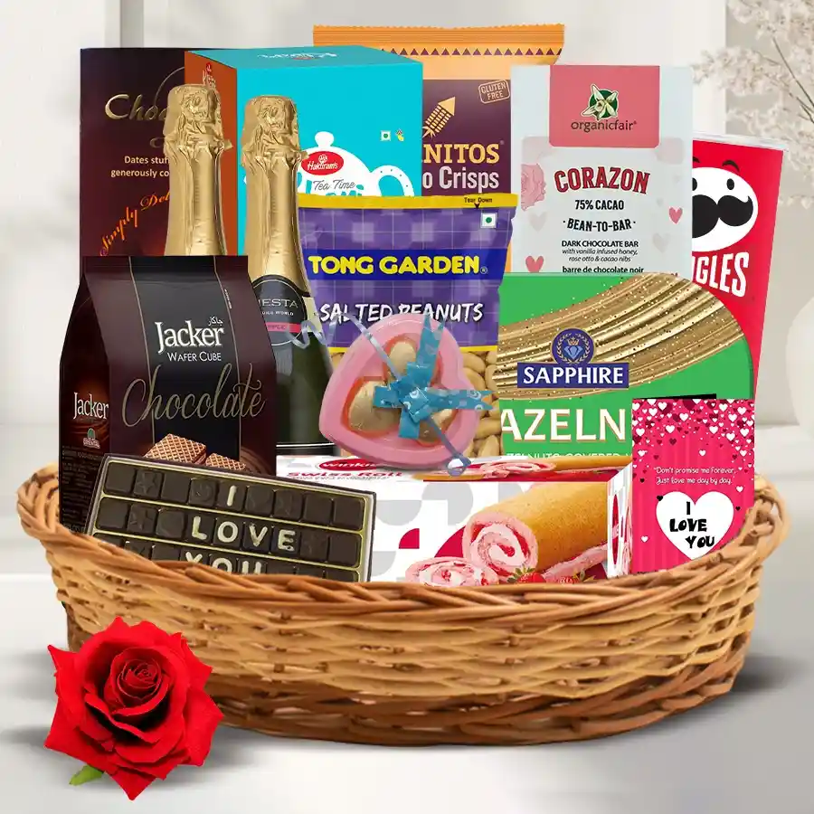 Marvelous Food Assortments Gift Hamper featuring Fiesta Apple Juice, Cornitos Nachos, assorted chocolates, Pringles, handmade chocolates, a red velvet rose, and an "I love you" card in a woven basket.