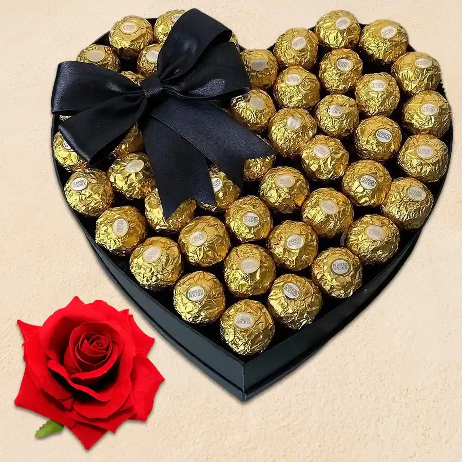 Heart-shaped Ferrero Rocher chocolates arranged with a red velvet rose and a golden bow