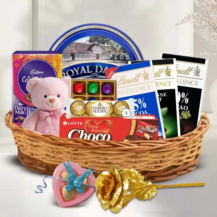 Delectable Chocolate Assortments Gift Hamper featuring assorted chocolates, a teddy bear, a lamp, a plant, and golden roses.