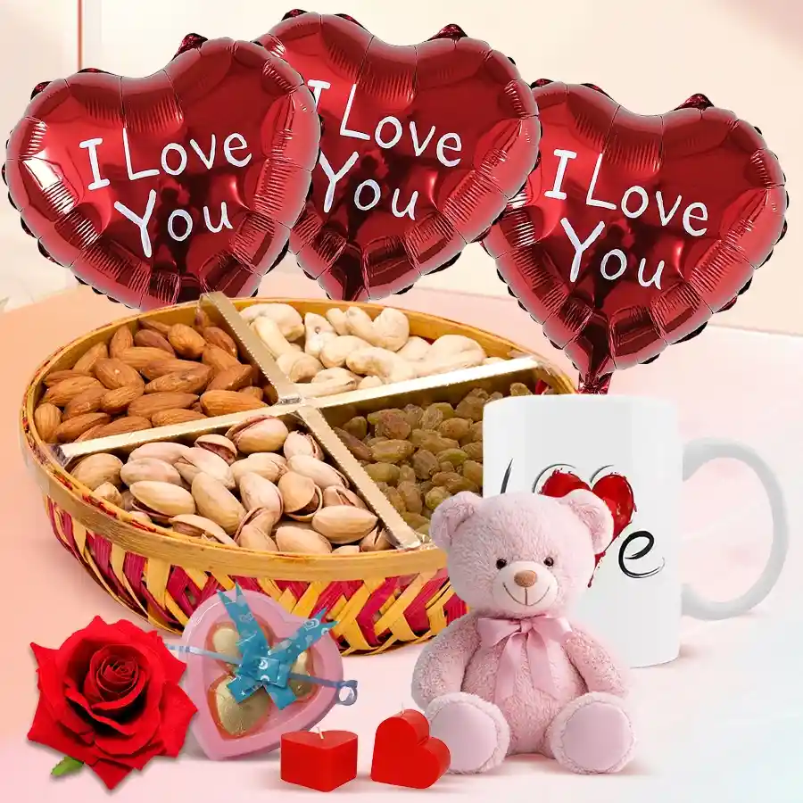 Valentine's Day dry fruits basket with pistachios, almonds, raisins, cashews, heart-shaped candles, a red velvet rose, a teddy bear, love-themed balloons, a charming mug, and homemade chocolates.