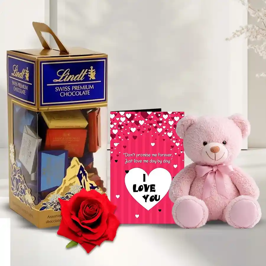 Mesmerizing Chocolate Gift Pack featuring Lindt Swiss Chocolates, a red velvet rose, a "I Love You" card, and a 6-inch teddy bear.