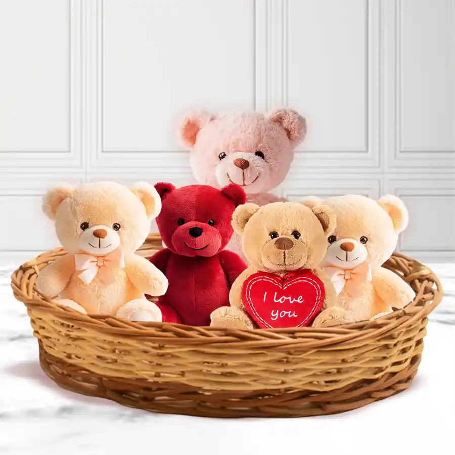 A beautifully arranged Valentine basket featuring a vibrant red teddy bear, a 6-inch "I Love You" bear, two 6-inch charming teddies, and a cuddly 8-inch pink teddy bear, all surrounded by decorative elements to celebrate love.