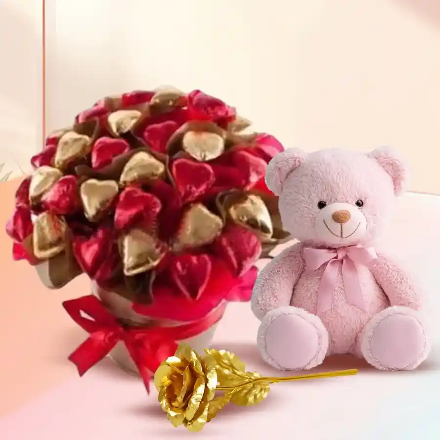 Heart-shaped chocolate bucket filled with handmade chocolates, a teddy bear, and a golden rose.