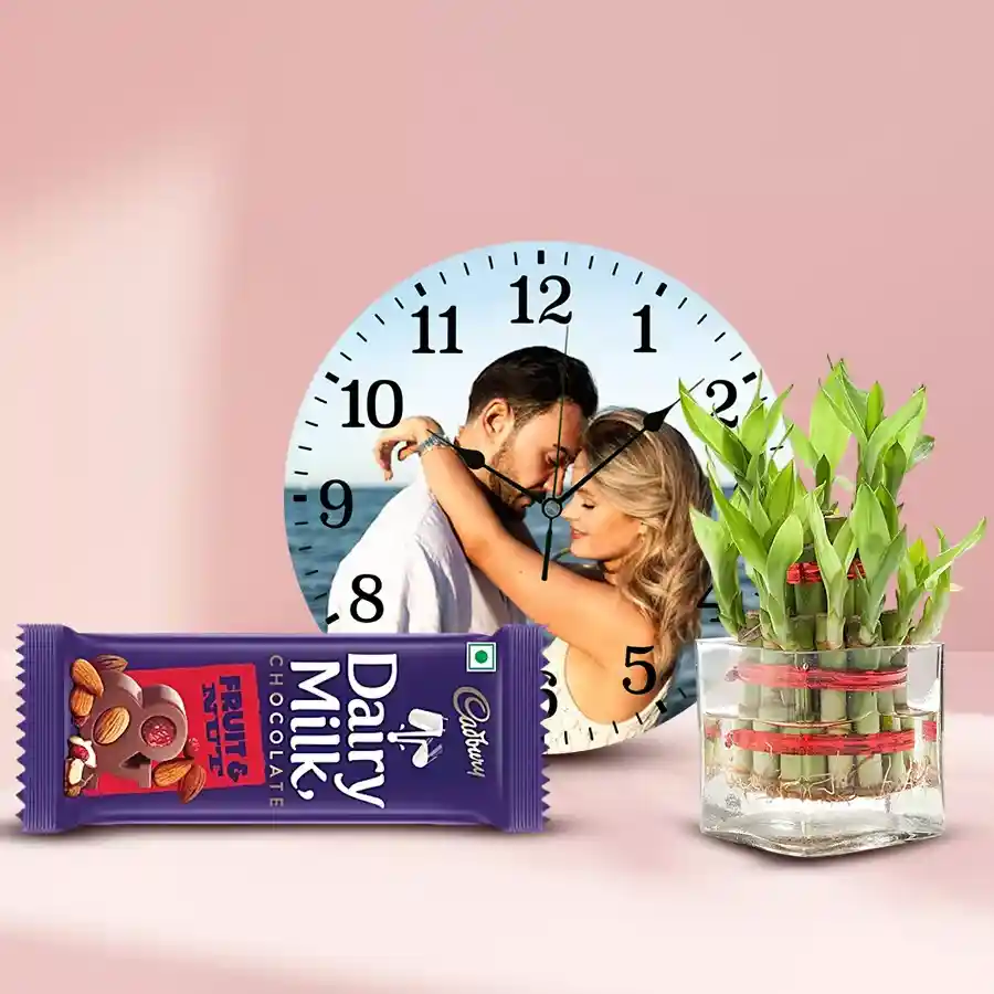 Personalized photo wall clock with a lush Lucky Bamboo plant and Cadbury Dairy Milk Fruit & Nut chocolate bar, perfect Mother's Day gift