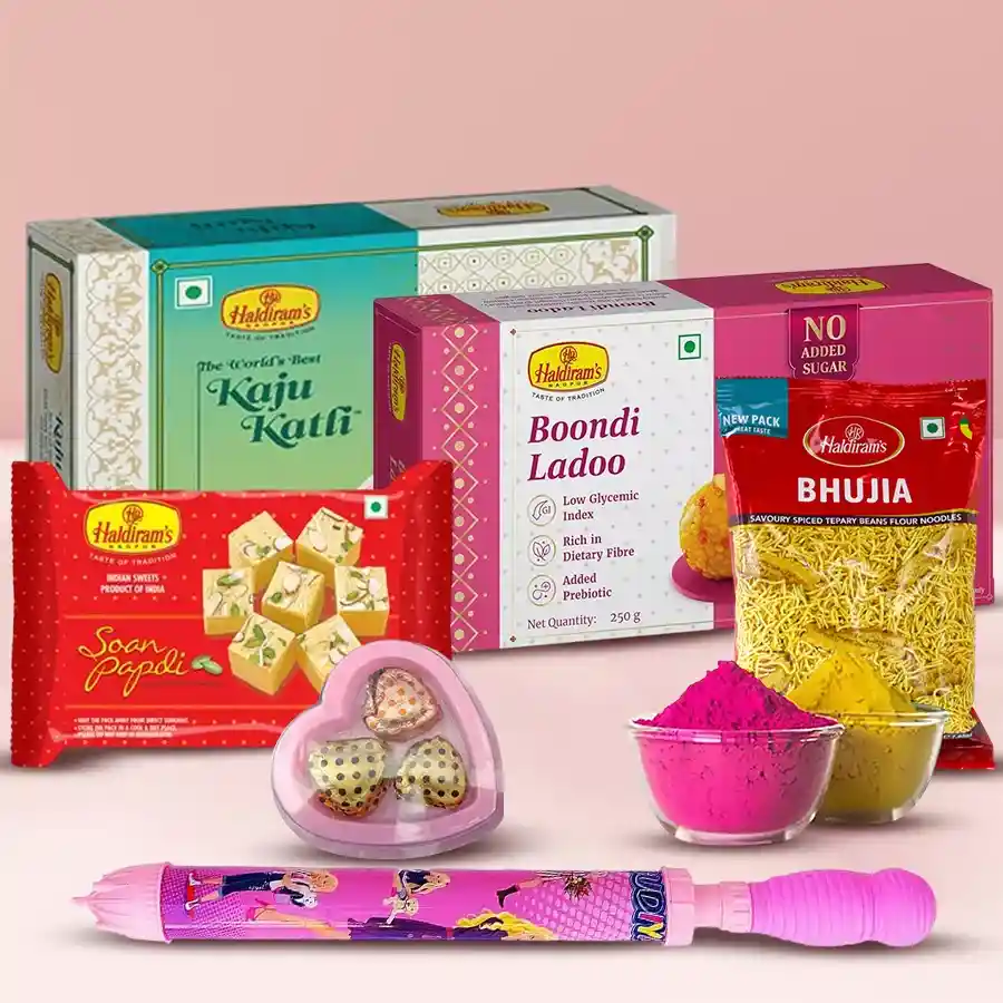 Luscious Sweets n Namkeen Gift Combo featuring Soan Papdi, Kaju Katli, Bhujia, Boondi Ladoo, heart-shaped chocolates, a pichkari water cannon, and colorful herbal gulal for Holi celebrations.