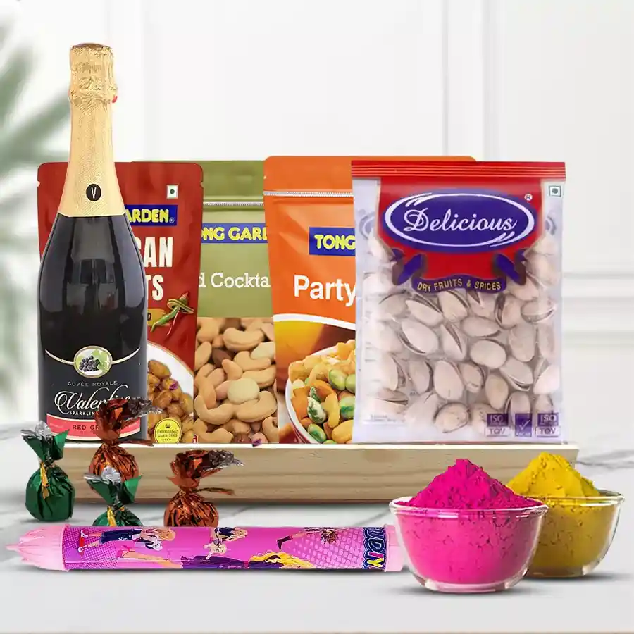 Gift hamper featuring assorted dry fruits, sparkling grape drink, party snacks, pistachios, peanuts, handmade chocolates, colorful pichkari, and herbal gulal arranged on a wooden tray.