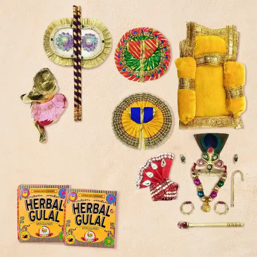Laddu Gopal Ji adorned with mukut, mala, bansuri, pagdi, fan, gadde, nappy, and two colorful cotton dresses, with packets of herbal gulal for Holi celebration.