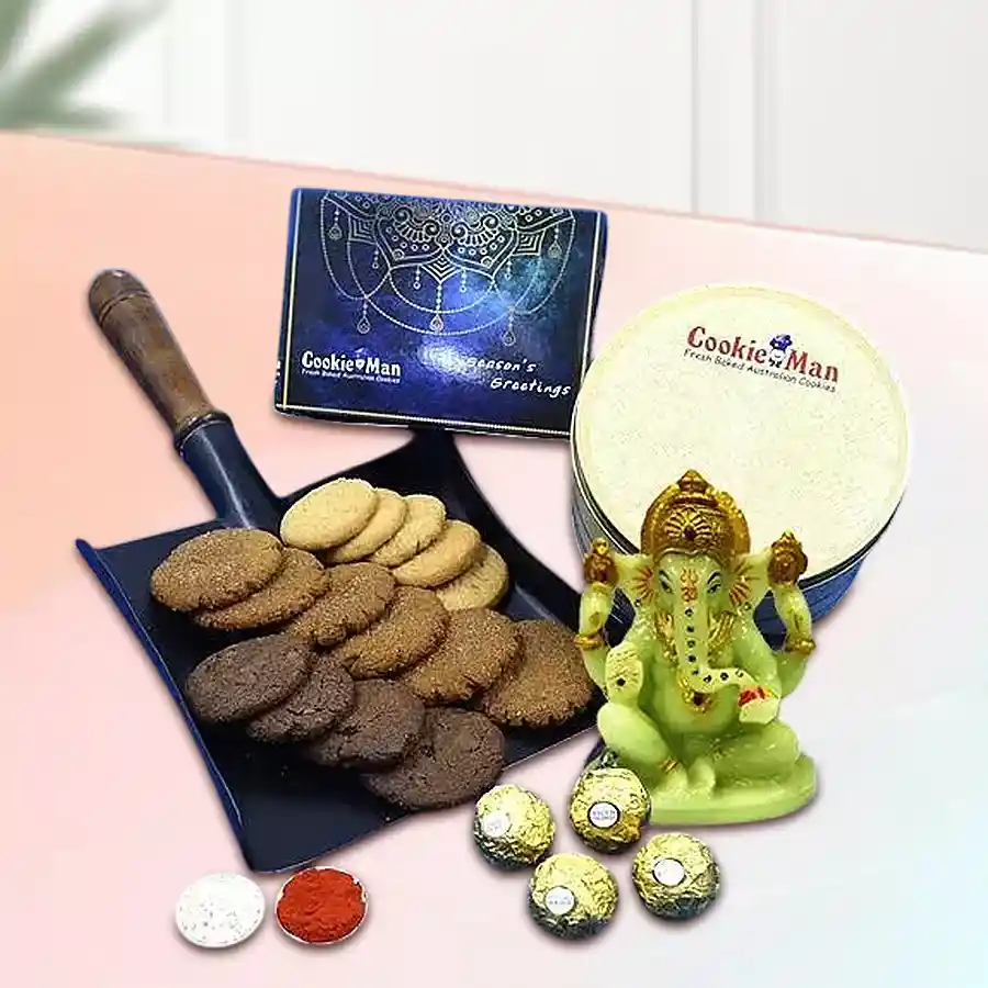 Lovely Cookie Man Cookies N Ferrero Rocher Combo with Glowing Ganesha idol, Roli Teeka, and Chawal on a decorative background