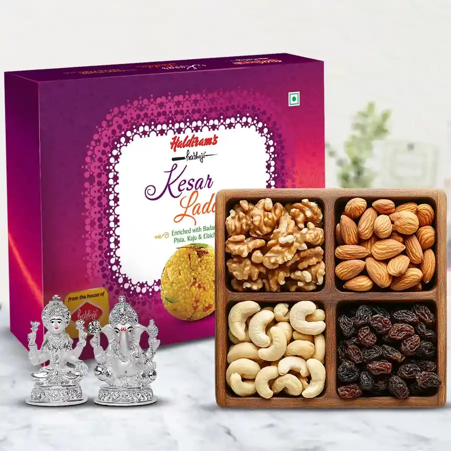 Tempting Haldiram Kesar Laddoo and Dry Fruits Idol hamper featuring a beautiful Laxmi Ganesh idol, Haldiram Kesar Laddoos, and assorted dry fruits arranged in a cardboard tray for Diwali celebrations.