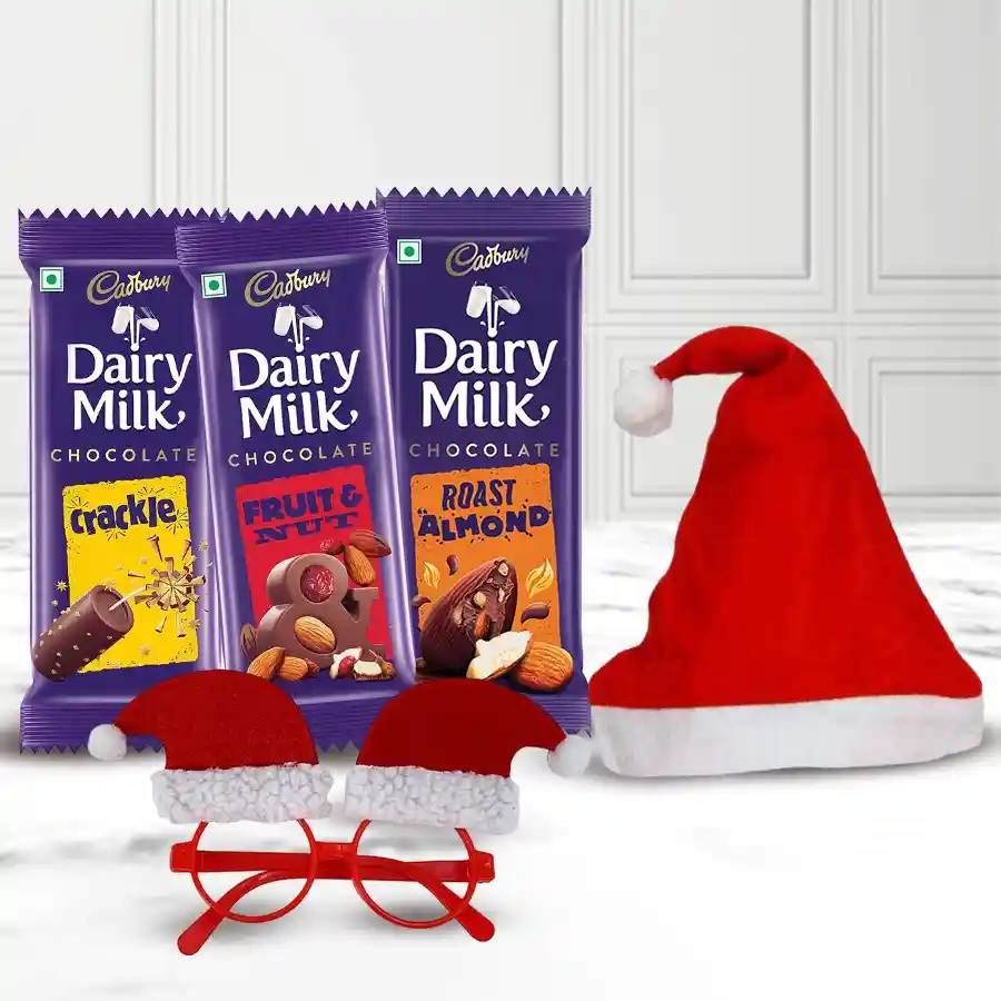 A festive gift set featuring Cadbury chocolates and Christmas accessories for kids, including cap bands and goggles, arranged in a cheerful holiday theme.