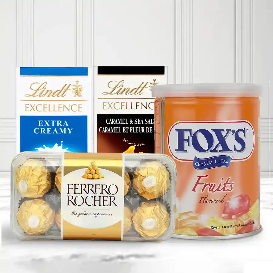 Finest Christmas chocolates gift combo featuring Lindt chocolate bars, Ferrero Rocher chocolates, and Foxes fruit flavour candies tin.