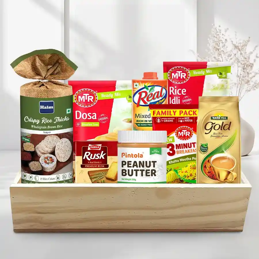 A beautifully arranged wooden tray filled with HAIM Organic Brown Rice Cakes, Pintola Peanut Butter, Real Fruit Power juice, MTR breakfast mixes, Tata Tea Gold, and Parle Rusk, perfect for a holiday breakfast gift.