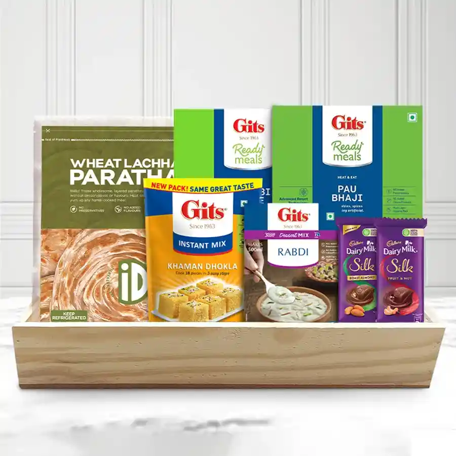 Royal Treatment Breakfast Hamper containing iD Wheat Parota, Gits Punjabi Chhole, Pav Bhaji, Cadbury Silk chocolates, and Rabdi dessert mix, elegantly arranged on a wooden tray for Christmas.