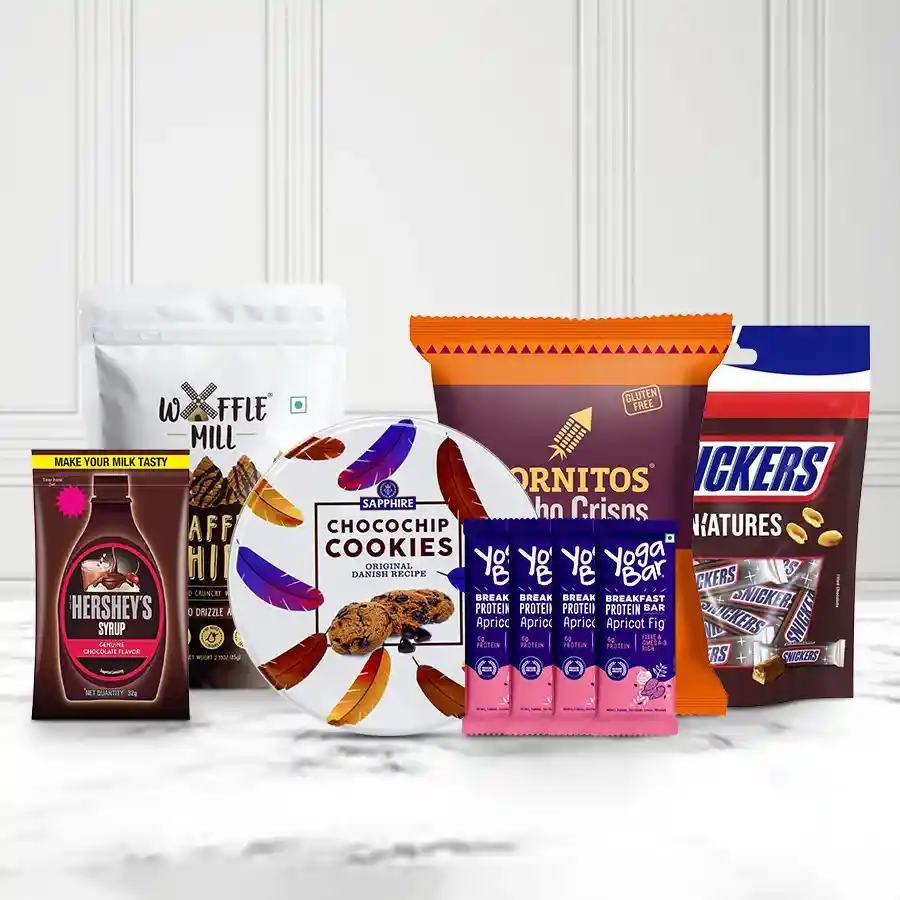 Special Choco Delight Hamper featuring waffle chocolate chips, Cornitos nachos, mini Snickers bars, chocolate syrup, Kravour cookies, and Yoga protein bars in a festive arrangement.