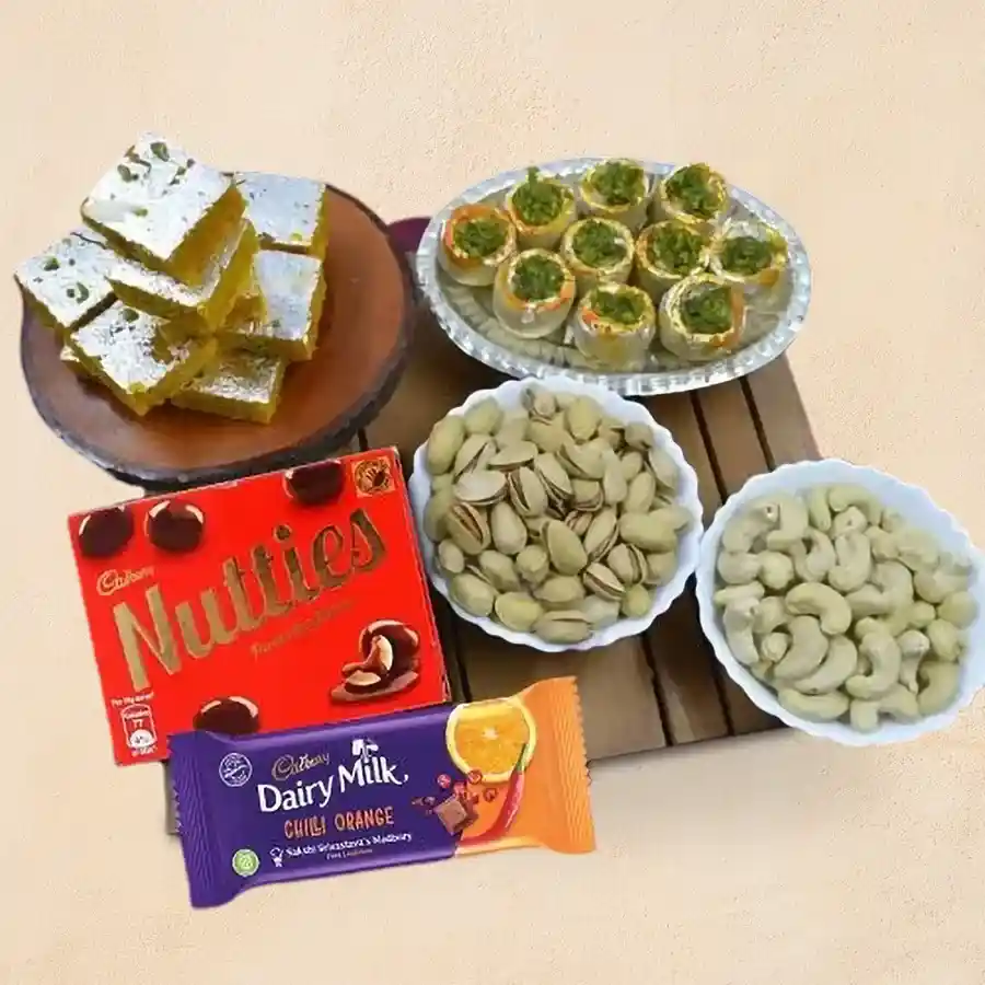 Classy gift hamper featuring Haldiram sweets, Cadbury chocolates, and premium dry fruits arranged elegantly.