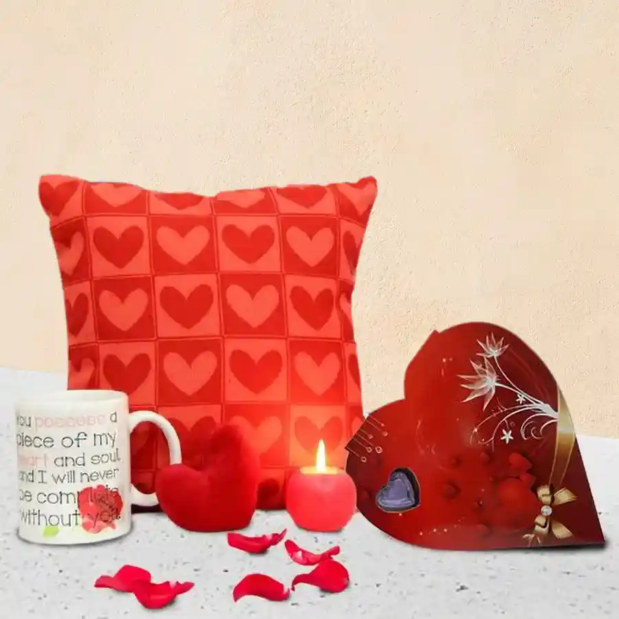 Enticing gift combo featuring heart-shaped chocolates, a plush heart toy, a cozy cushion, a glowing ball candle, and an adorable coffee mug