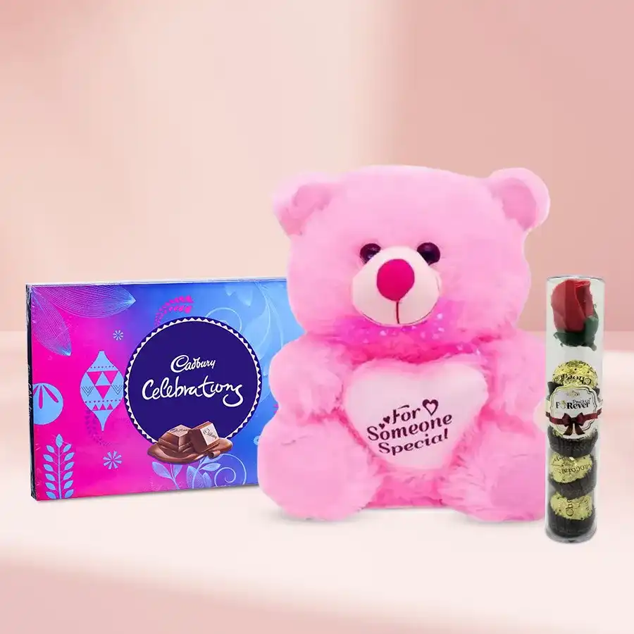 Heart-shaped teddy bear with handmade chocolates and a pack of Cadbury Celebrations in a romantic setting.