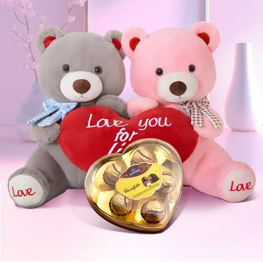 Enticing twin teddy bears with hearts and a box of heart-shaped Sapphire Hazelfills chocolates in a decorative love box