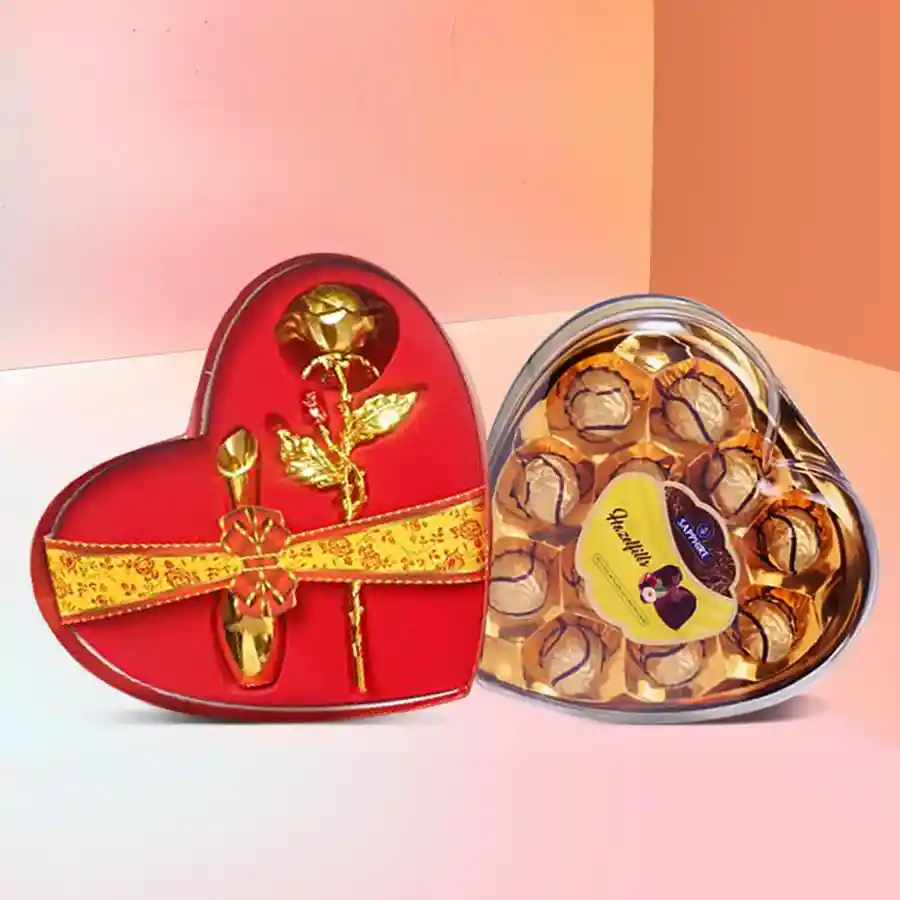 Heart-shaped box containing golden roses and Sapphire Hazelfills chocolate hearts.