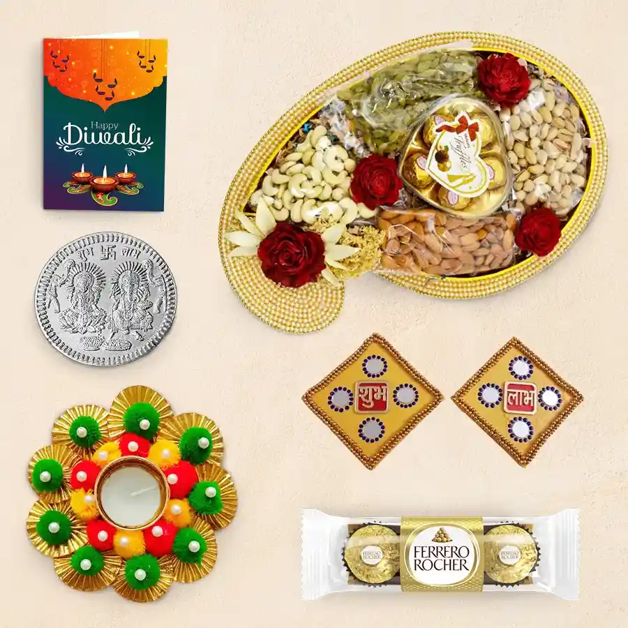 Diwali gift hamper featuring a Pearl Chopra Tray with assorted nuts, chocolates, a designer diya, Shubh Labh wall stickers, a silver-plated coin, and a Diwali greeting card.