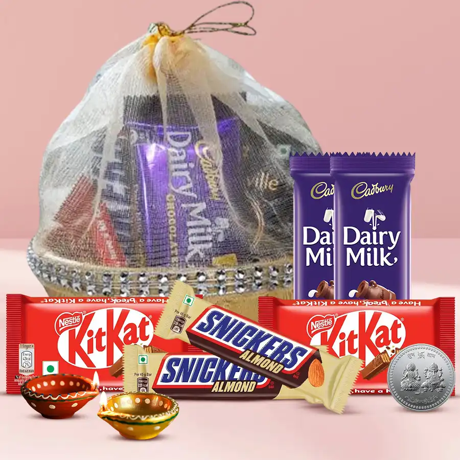 Cadbury Chocolicious Marvel Hamper featuring chocolates, wax diyas, and a silver-plated Ganesh Lakshmi coin in a beautiful gift basket