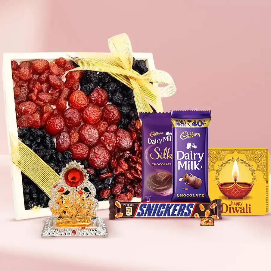 Nutty Tray of Diwali Wishes featuring a wooden tray filled with mixed berries, Cadbury Dairy Milk Silk bars, Snickers bars, a Ganesh Lakshmi Mandap, and a festive fridge magnet.