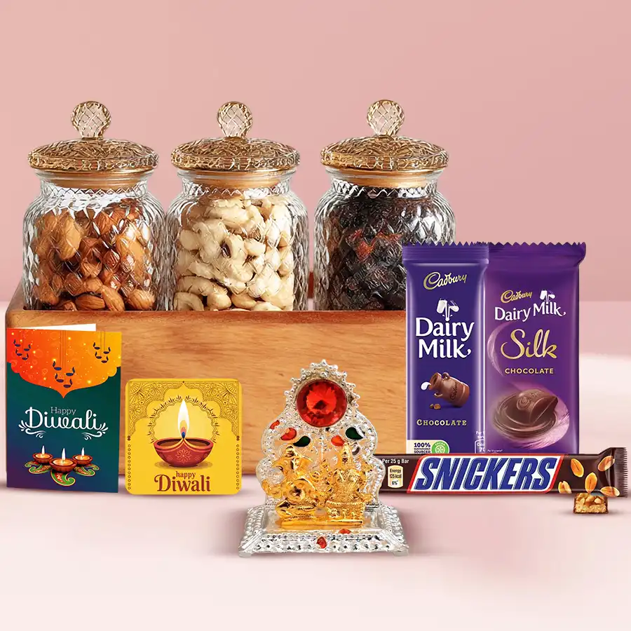 Delightful Chocolates n Nuts Gift Treat featuring a reusable wooden tray with three glass jars of cashews, almonds, and raisins, alongside Cadbury Dairy Milk Silk, Dairy Milk, and Snickers chocolates, a Ganesh Laxmi Mandap, a handmade fridge magnet, and a Diwali wishing card.
