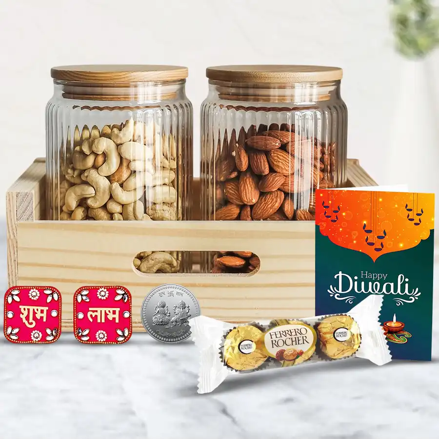 Joyous Treat Diwali Gift Box featuring a wooden tray with glass jars of cashews and almonds, Ferrero Rocher chocolates, a designer diya, Shubh Labh wall stickers, a silver-plated coin, and a Diwali greetings card.