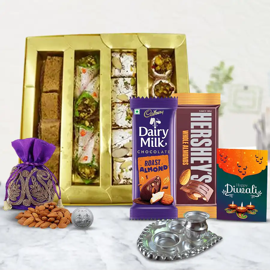 Diwali gift box filled with Kaju Pan, Milk Cake, crunchy snacks, Cadbury chocolates, Hershey's almond chocolates, silver-plated Ganesh idol, Pooja Thali, almond potli, and a festive card