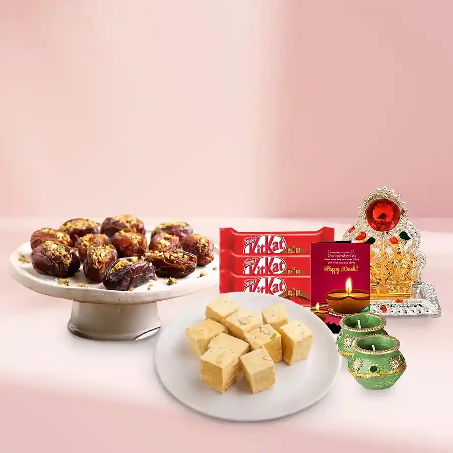 Dates Baklava Delight gift basket featuring 250g Dates Baklava, 200g Soan Papdi, Nestle KitKat Chocolate Fingers, decorative wax diyas, Ganesh-Laxmi mandap, and a Diwali card.