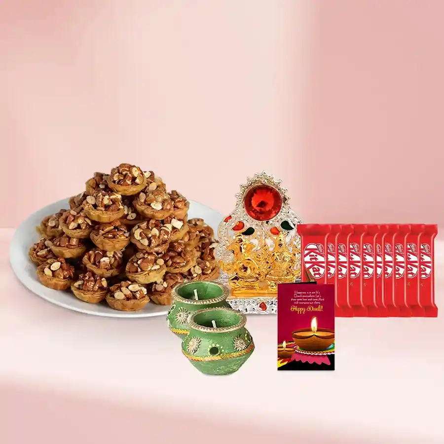 Special Tart Baklava and KitKat Moments Basket with decorative wax diyas and Ganesh Lakshmi Mandap, arranged in an elegant basket